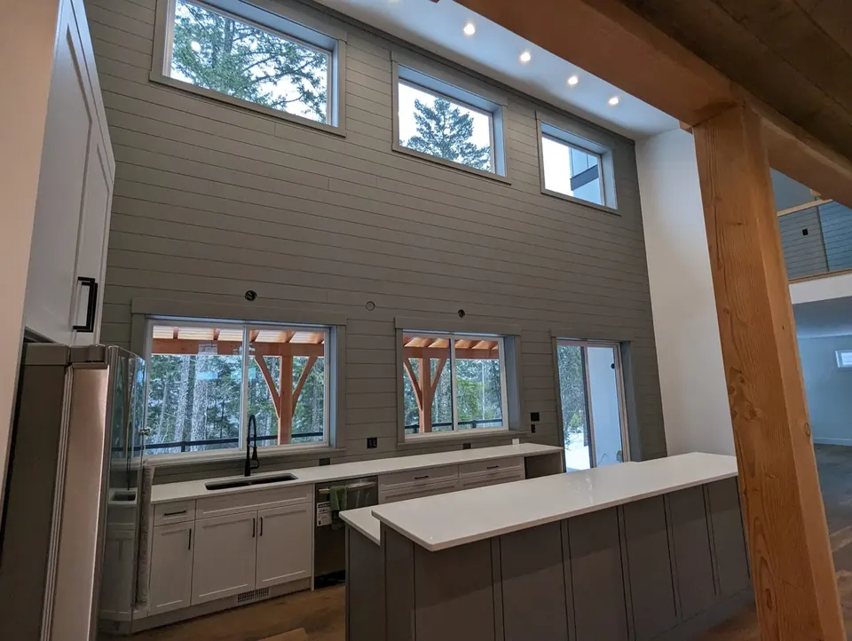 Condo kitchen with a green-grey shiplap wall and timber post