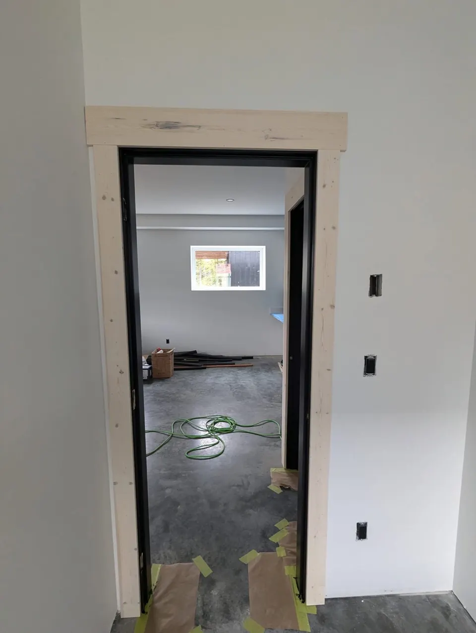 Doorway with black jamb looking into a white room
