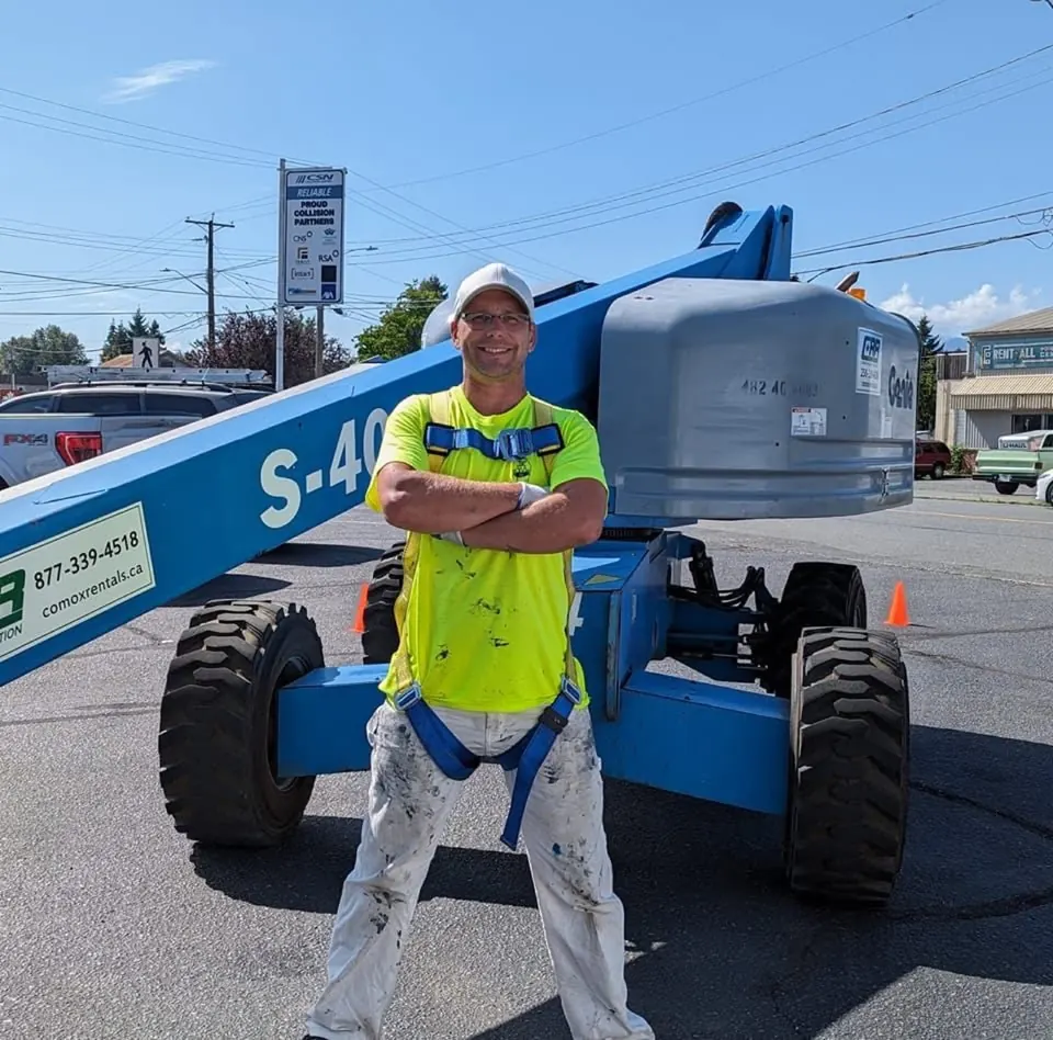 Rory Somers standing in front of a boom lift on a job